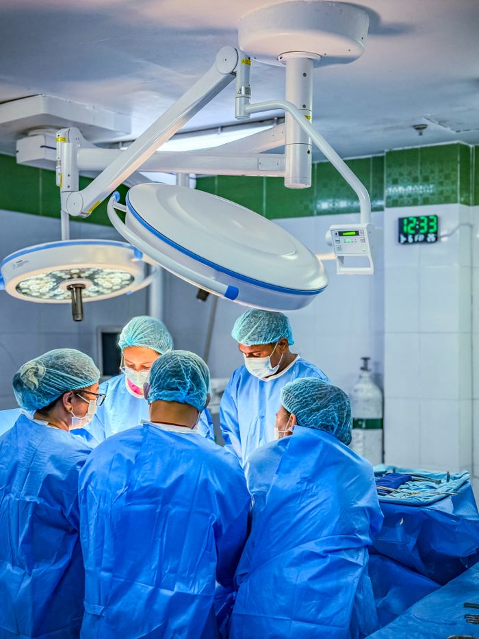 Doctors performing surgery in a sterile, brightly-lit operating room in Cebu City.